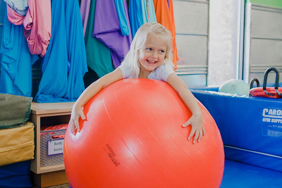 Photo of a little girl playing with an exercise ball