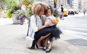 Mother embracing daughter on the sidewalk of New York City