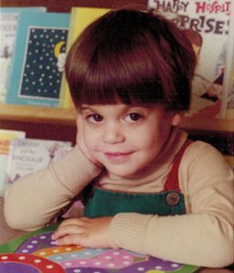 Occupational Therapist Andrew Klein as a young boy sitting at a table with a workbook