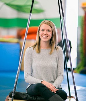 Brooke Brees, directora clínica de terapia ocupacional, terapeuta ocupacional sentada en un columpio de plataforma