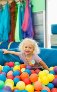 young girl sitting in ball pit in the sensory gym