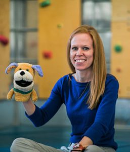 Speech Language Pathologist Kelly Jones with a dog puppet