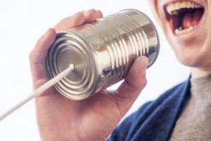 man yelling into a tin can indicating he is communicating