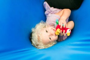 girl with bird toy in a swing, Sensory Integration - pediatric therapy durham