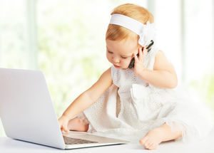 baby playing on phone and computer