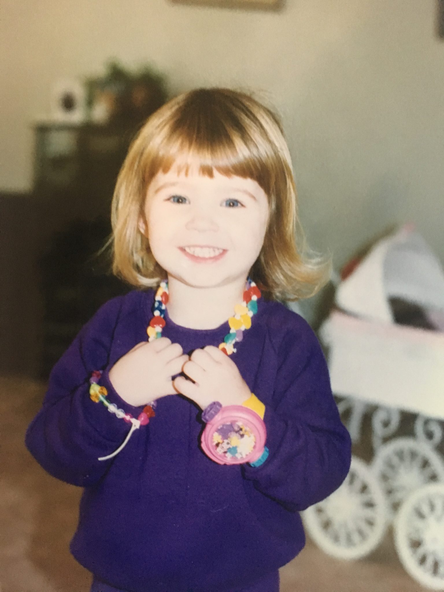 Speech Language Pathologist Laura Strenk as a girl, wearing a purple sweater with toy jewelry