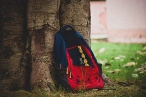 backpack resting on a tree