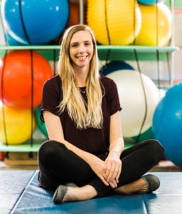 Kristina Graven, occupational therapist sitting in the therapy gym