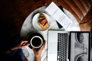 Macbook Pro with coffee and breakfast at a cafe