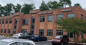 Two story brick building with large windows. Large white letters go across the top of the building announcing the names of the businesses inside, including Emerge Pediatric Therapy