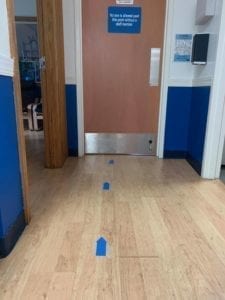 blue arrows on the floor leading to the gym entrance door