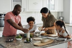 family of four made of dad, mom, son and daughter, making breakfast in a modern kitchen