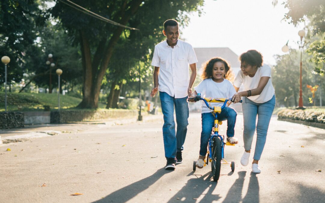 man-standing-beside-his-wife-teaching-their-child-how-to-1128318