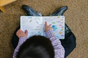 aerial view of a dark haired child reading the pout pout fish book