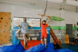 Boy swinging from a trapeze swing in the Sensory Gym