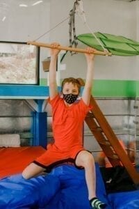 Boy swinging from a trapeze swing in the Sensory Gym