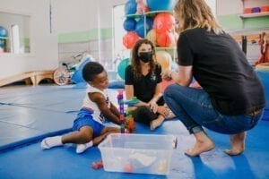 Two Female therapist working with a child in a Sensory Gym