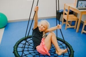 Girl enjoying swinging on a Spider Web Tree Swing