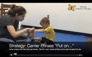Profile view of a brunette speech therapist holding a Mr. Potato head toy along with a small boy in a yellow shirt.