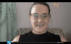 Close up photo of a white speech therapist in glasses and a black sleeveless top