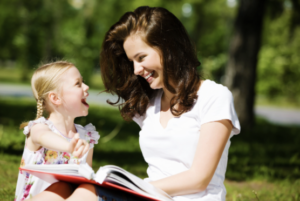 a girl and her mom are laughing at a book