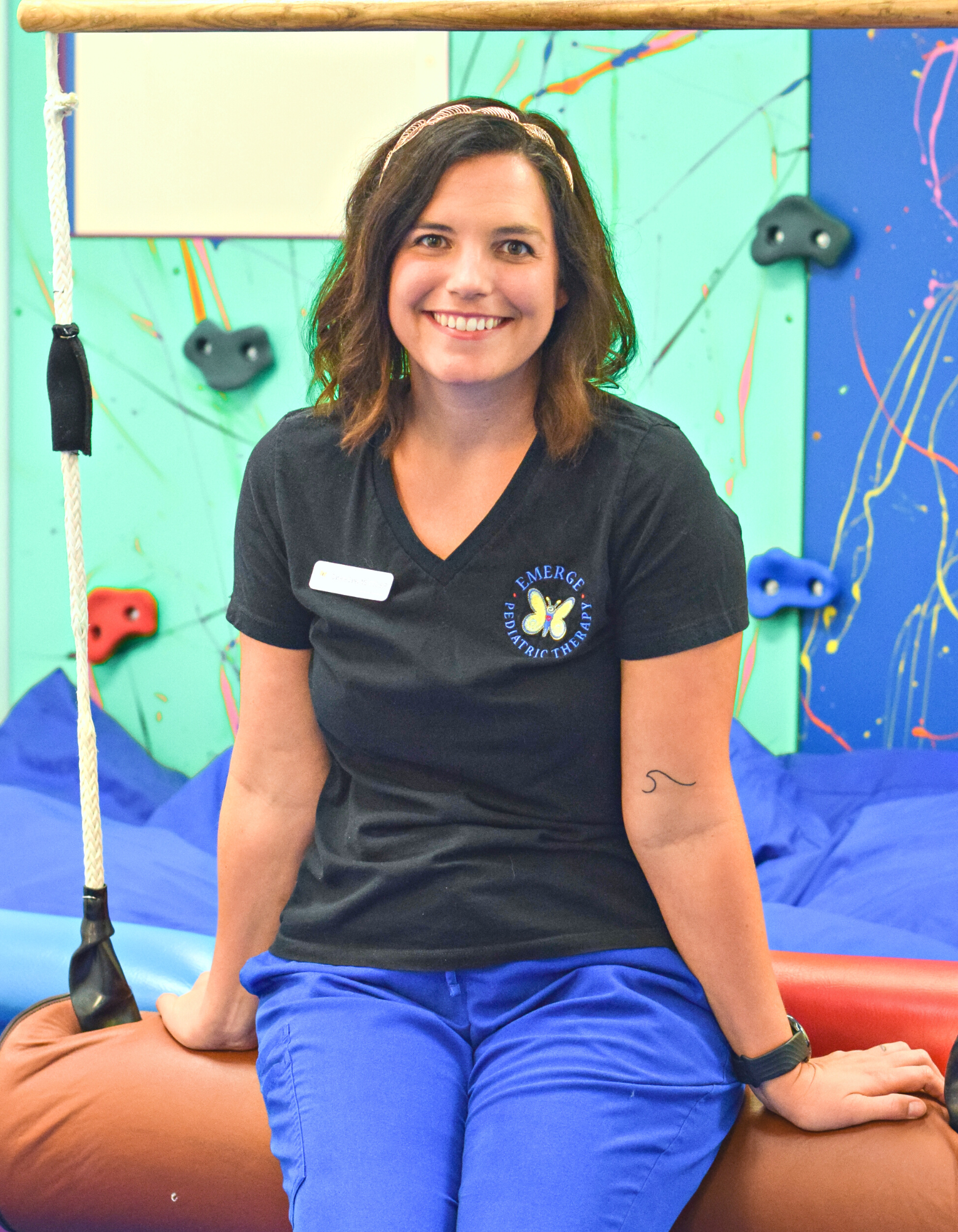 Speech Language Pathologist Danielle, seated in the Sensory Gym