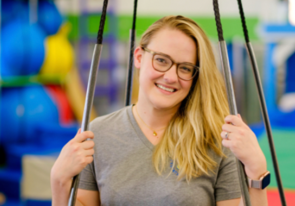 EXECUTIVE DIRECTOR Brittni smiling in the Sensory Gym