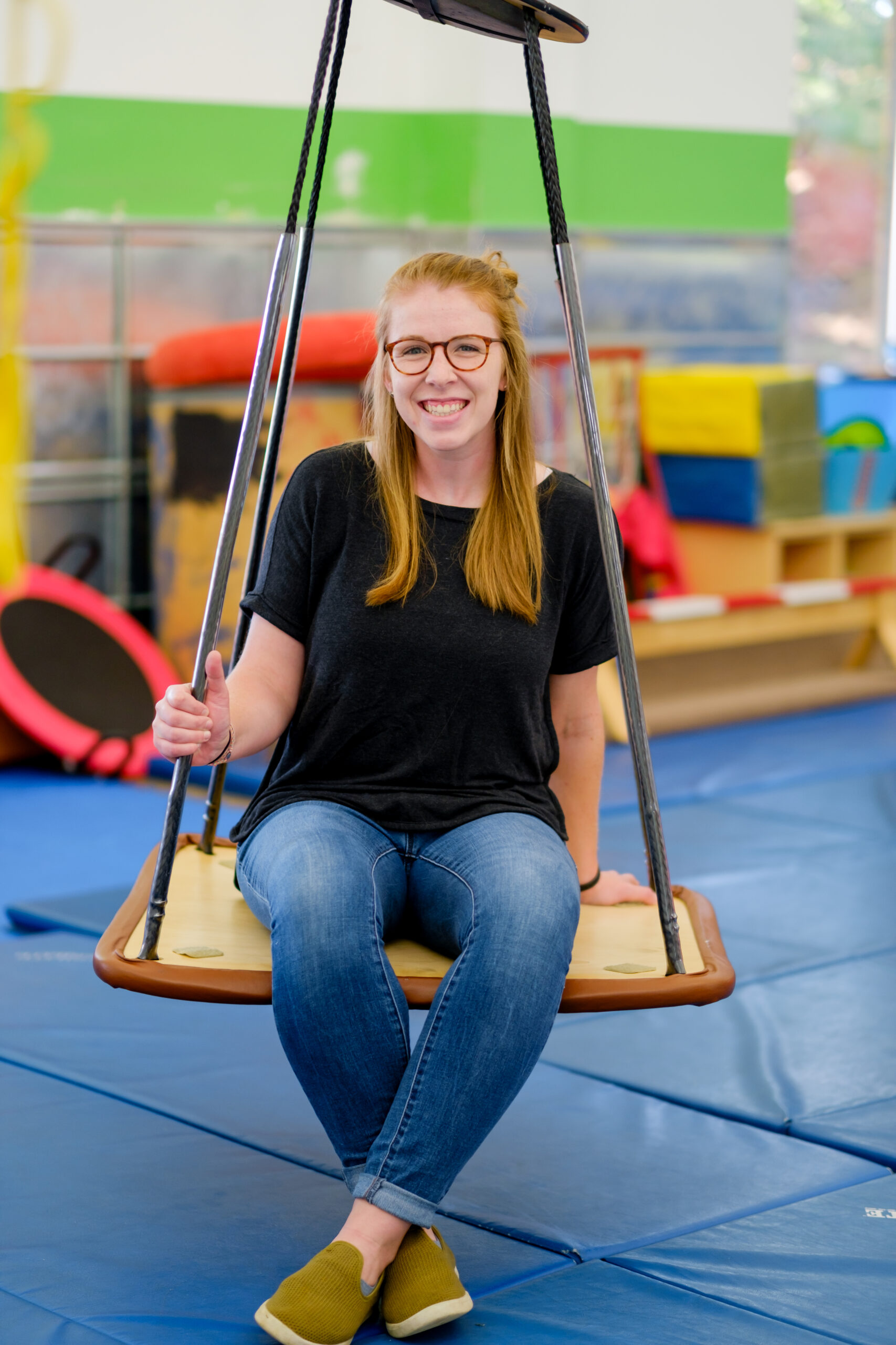 Occupational Therapist Maddy sitting in the Sensory Gym