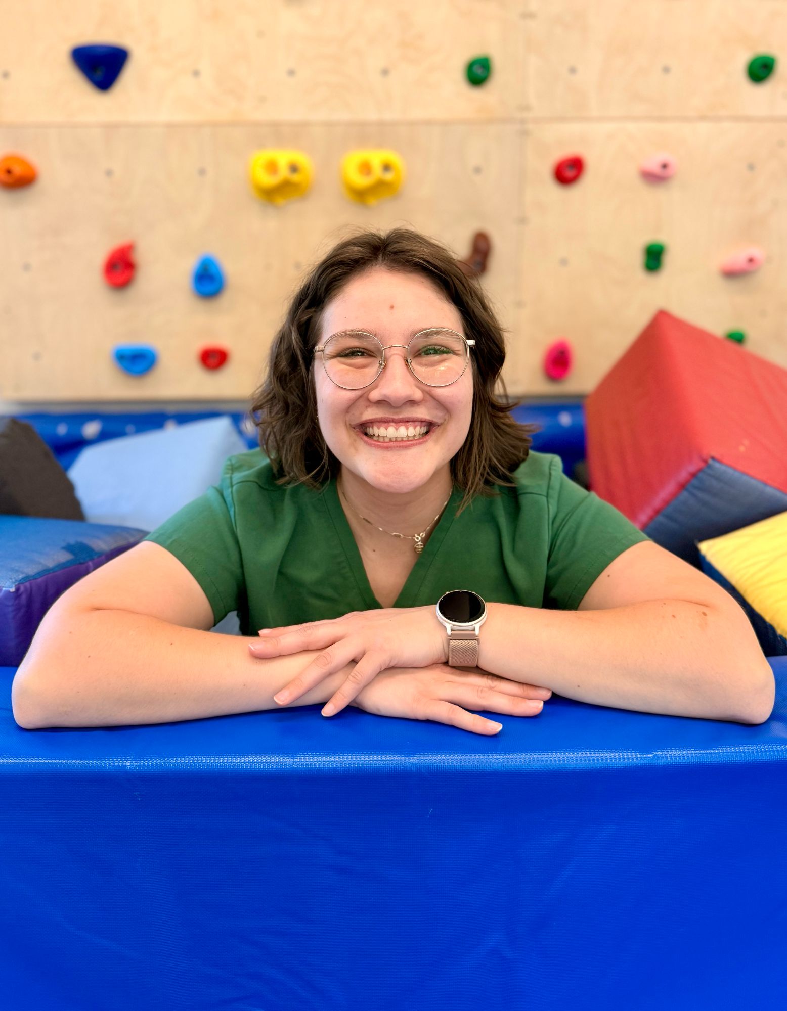 Speech Language Pathologist Laura sitting in sensory gym